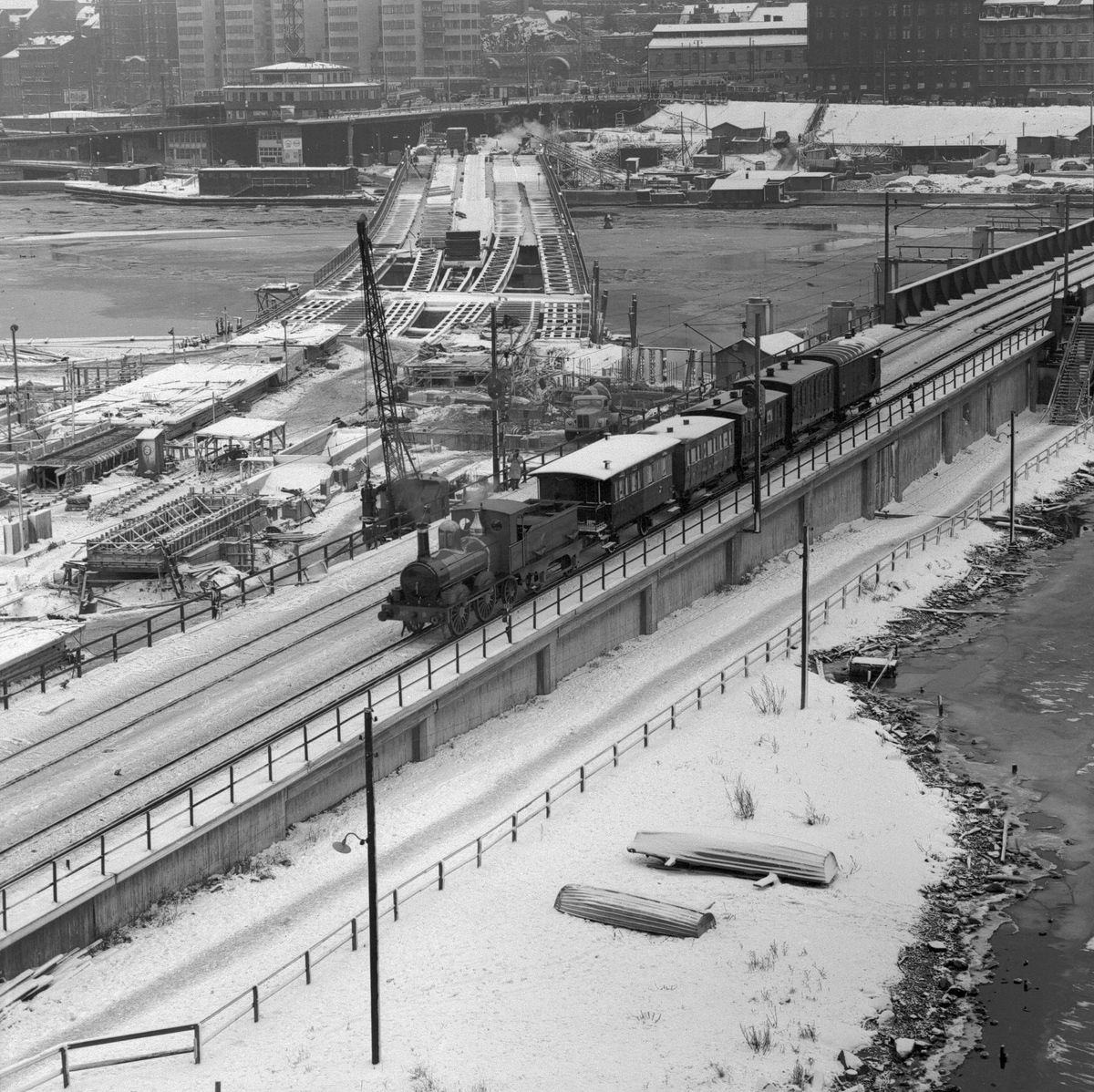 Statens Järnvägar SJ 1856-1956. 100-årsjubileum.Tåg med gamla lok och vagnar vid Södra Järnvägsbron på sträckan mellan Riddarholmen och Mälarstrand..