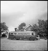 Gengasdrivenbuss. Lastning av bagage på busstaket.