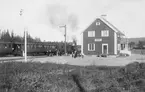 Leksboda stationshus med persontåg vid plattform.