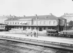 Eskilstuna Centralstation stationshus med personvagn och malmvagn.