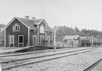 Rällså stationshus med personal på plattform.