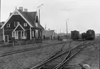 Tvåaxlig vagn av SRJ äldre serie, tydligen en CD-ombyggn. (nr 5-7) Boggivagn ur serien 59-61 (Fole 1906). Till höger en av Djurholmssläp 23-24, ombyggd 1910 för ånglinjerna (boggier m. normalhöga hjul). (1918 motoriserades även korgen breddad + ellipstak)