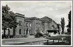 Kristianstad station sedd från väg med fordon i bild.