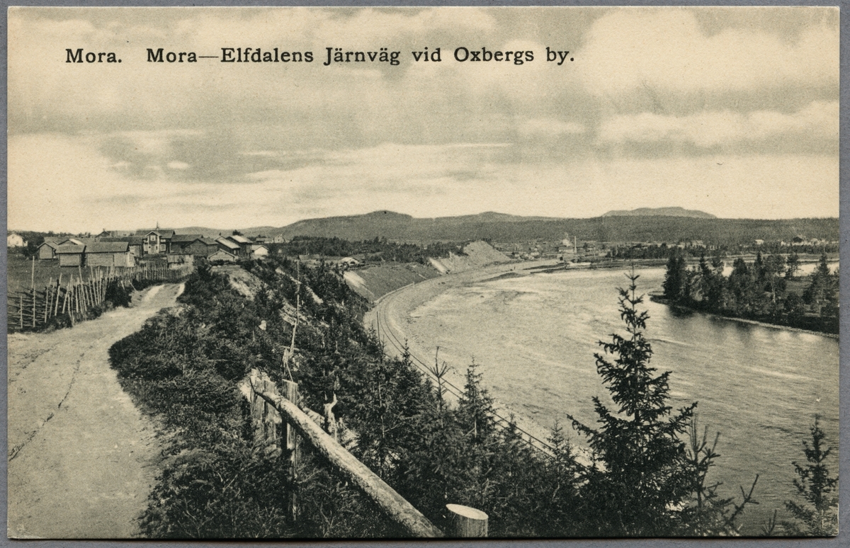 Oxbergs by vid Västerdalälven, med Blybergs porfyrberg i bakgrunden.