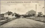 Spårvagn på grusgata passerar Nissens chokladfabrik i stadsdelen Kneippen, Norrköping.