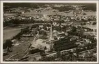 Flygfoto över Matfors med Ljungan och fabrik i bild.