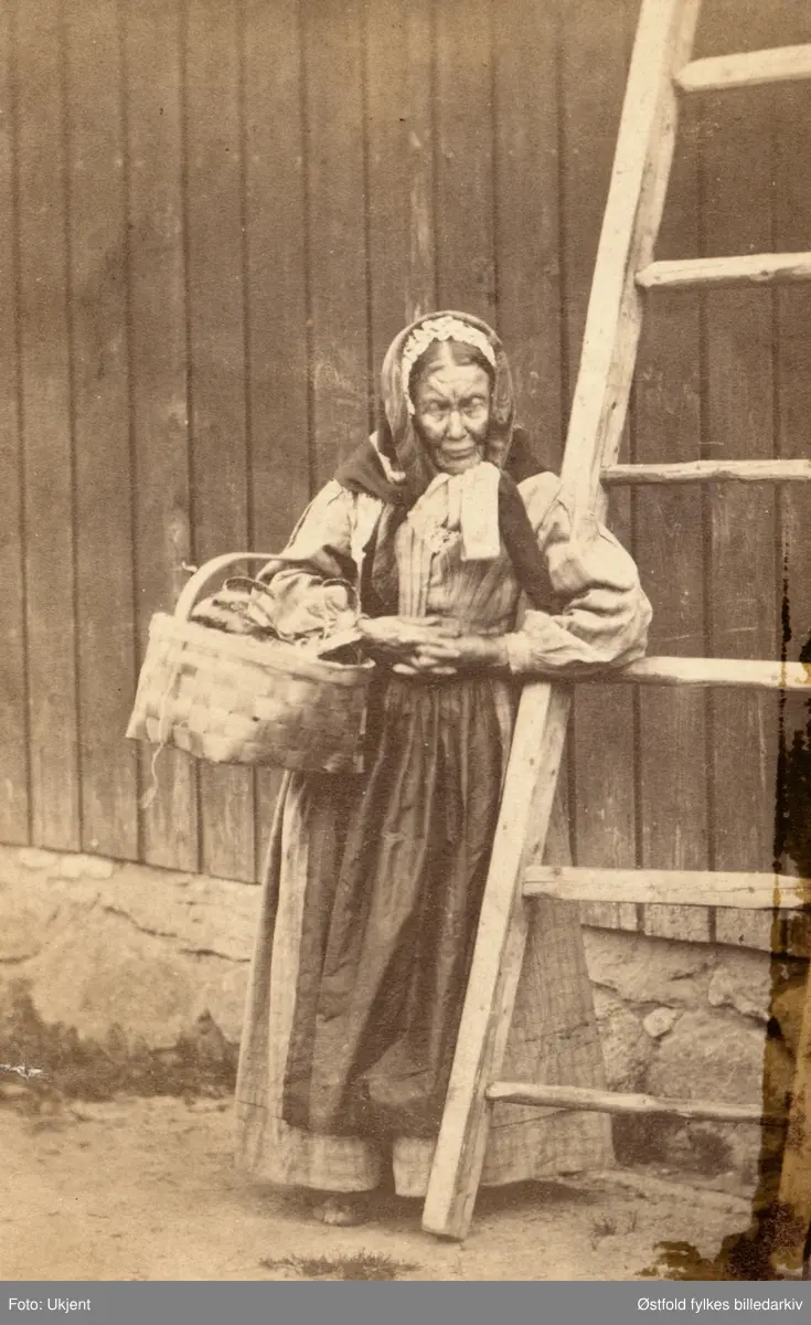 Mari Bøa i Råde, legdekjerring i Råde, ca. 1865-70.
"Lægdekjærring Mari Bøa vanket stadig paa Færjestan og fik sig en taar Kaffi" påskrevet på bakside av visittkort.
Færjestan på Solli i Tune.

"Ho Mari jikk i nøa, å selte gåtter og tigde føa. Ho var en stann å tente, der der va læit å væra, fekk e sjeppe poteteter te  å setta i lønn. 
- jæ fekk sett e sjeppe poteter da døm sette sinne, å de første døm bynnte å ita tå de var  minne - de vet ingen åt jæ læi  dem de så, det, sao Mari Bøa .Etter Kristian Strømshaug, Råde. 
Originalfoto i visttkoprtformat innkommet 1977 (fra hvem?), skriver Truls Nygaard.