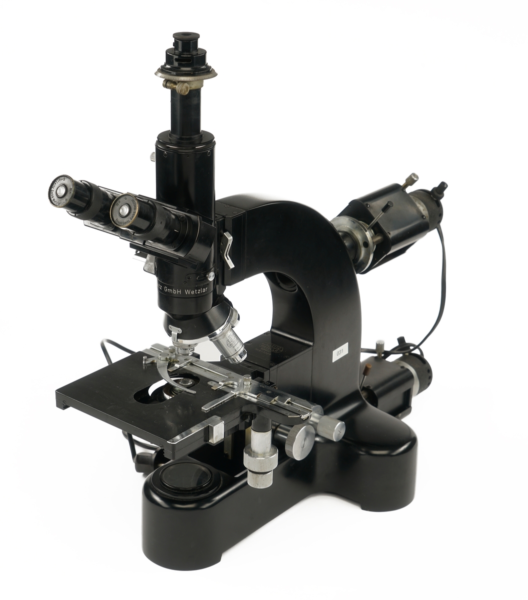 Mikroskop med tre okkularer samt tilkoblet to strøm/lyskilder og medfølgende utstyrskasse i tre som inneholder:
Tre beskyttelseshetter av plast
To okkularer
Tre objektbord
Syv objektfiltere
fire ulike linser
En glassflaske med Immersions olje
En plastpipette for antatt olje
To lyspærer pakket i pappesker
Åtte blendere pakket i pappeske
En nøkkel til kassen pakket i papirpose
En pusseklut