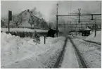 Bangården med stora snödrivor.Text på bilden - Efter det stora snöfallet under trettondagshelgen 1948.  Fjärrgodståg, fjgt,4301 under utfart mot Halmstadsbanan.