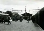 Resande på plattformen i Nässjö. Två tåg inne på stationen. till vänster tåg mot Oskarshamn.