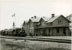 DONJ, Dala - Ockelbo - Norrsundets Järnvägsstation. Stationen öppnad 1895. Tvåvånings stationshus i trä, med tre gavlar mot banan. Postlokal och postmästarens bostad tyllbyggdes 1903. I samband med den nya genomfarten, länsväg 272, flyttades stationshuset till den nuvarande platsen vid Ockelbo station. På fotot syns extratåg med Malletlok för Svenska Järnvägsklubben. Ångloket är DONJ lok 12.  Det tillverkades 1910 av Atlas.