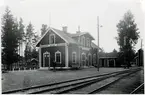 Älvans stationshus med stationsinspektor poserande framför stationshuset.