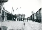 Stationsinspektor John Ahlberg, i bildens mitt, vid Svanebergs station. Skara Kinnekulle Vänerns Järnväg ,SKWJ personvagn 536 står på spåret.