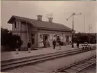 Knutby station. På fotot syns två stationskarlar till vänster. Mannen med flaggan är stationsskrivare. Till höger om damerna står stinsen Joel Karlsson.