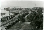 Korsnäs station samt sågverk vid sjön Runn. Stationshuset syns bland träden och bortanför syns såghuset med brädgården till vänster.