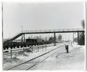 Övergångsbro vid Tureberg station. På spåret syns bland annat Statens Järnvägars godsvagnar SJ 5630, SJ 2434 och SJ 10996.