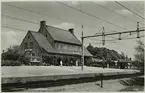 Bangården och stationshuset med resande. Pressbyråns vykort 5450.
