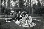 Långsjön midsommardagen 1942. Längst bak framför häcken till vänster: Lisa och Ingemar Aldenby. Längst bak från höger: Långsjö-Pelle i sin uniformsmössa och bredvid honom farfar Per Andersson och Tekla Andersson sittandes i vilstolen. I gröngräset till höger brudparet: Anders och Siri Lindgren och framför dem Björn Aldenby, son till Ingemar och Lisa.