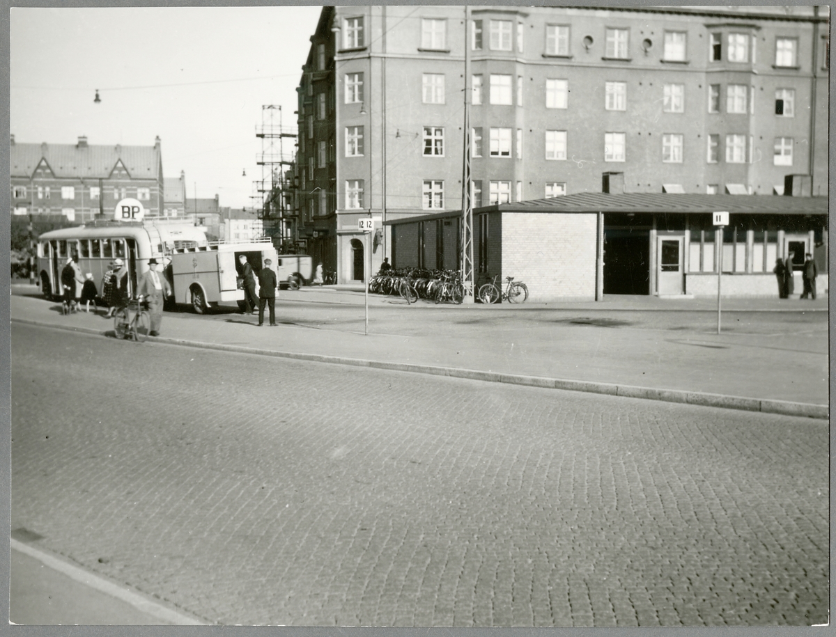 Busshållsplats med resande.