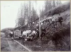 Banbyggnad av Mora-Elfdalens Järnväg 1898.
Rallare med befäl och två gruskärror.