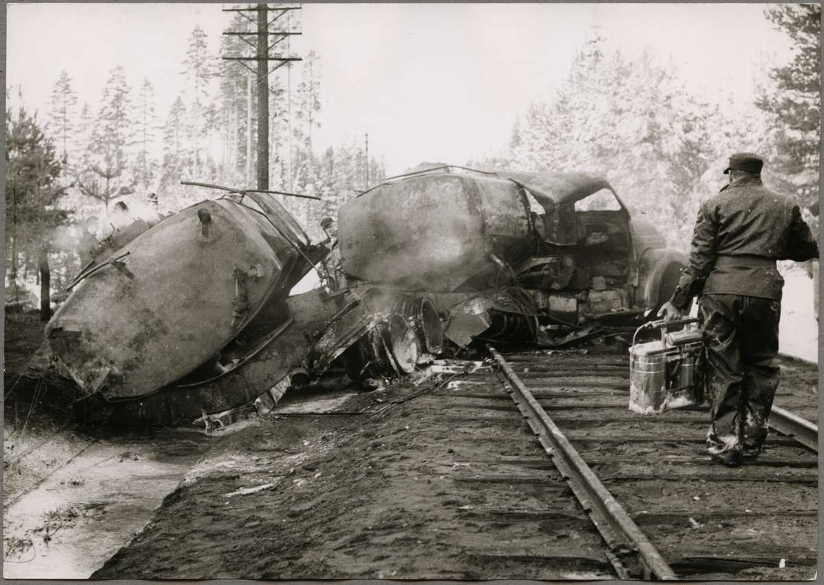 Tankbil som fattat eld efter kollision med tåg, på okänd plats.