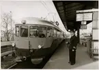 Trafikaktiebolaget Grängesberg - Oxelösunds Järnvägar, TGOJ Yoa 202 vid Kolbäck station.

TGOJ motorvagn med lokförare vid perrong med stins.