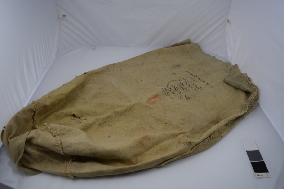 Original karduspose for drivladning tilhørende til 38 cm SK C/34 kanon på Møvig Fort. Sylindrisk form av et stykke med påsydd rundt bunn. To påsydde handtak. Håndsydde sting langs toppen.