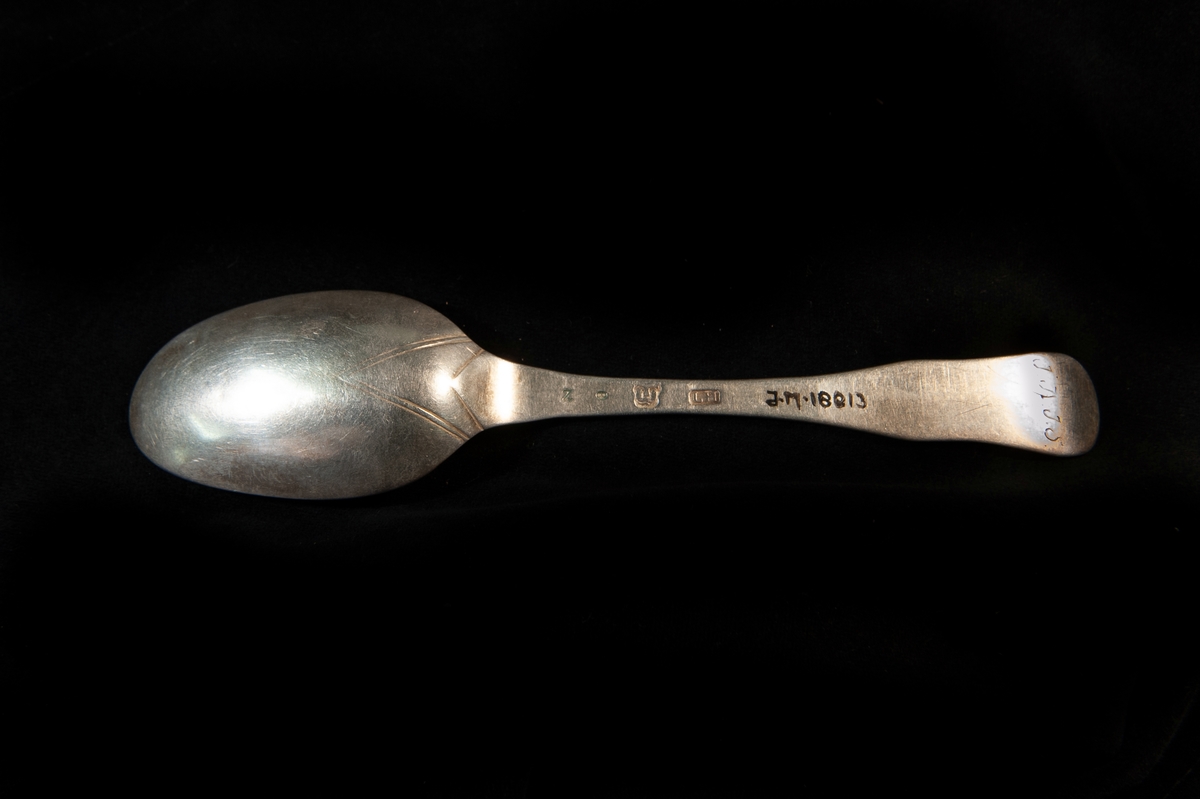 En matsked av silver. Enkel s.k. fiolmodell med antydantill ås. Stämplad på skaftets baksida.

Jfr JM 18809.