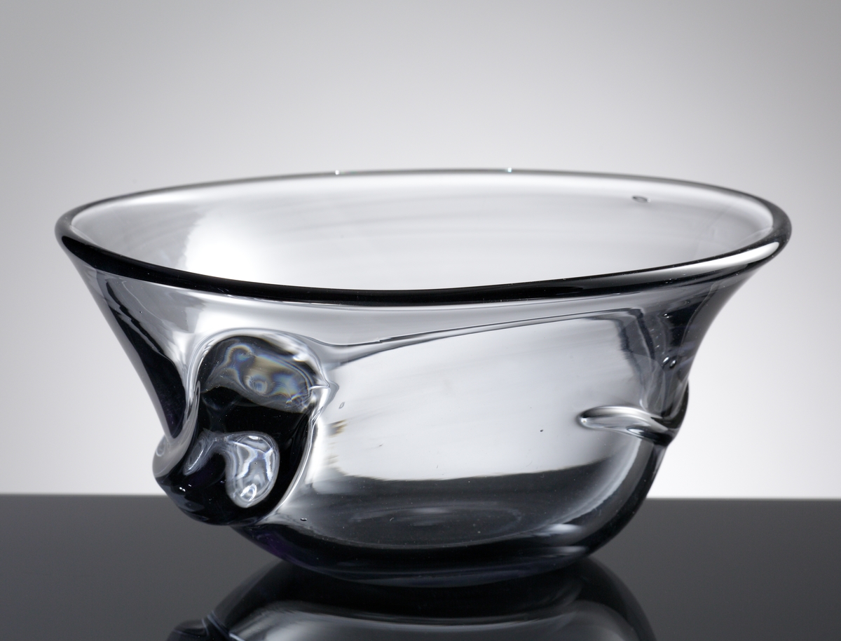 Ålskål. Formgiven av Hugo Gehlin. Se ritning.
Beskrivning: Klockformad med en ål virad runt om. Kulslipad botten.
Färg: Gråskimrande klarglas.
Mått: Ovan anges höjd och övre diameter. Bottendiameter: 96 mm.
Graverad märkning samt vit lapp med text. Se "Signering, märkning" 1 och 2 ovan.
Inskrivet i huvudkatalogen 1980.

Hugo Gehlin (1889-1953), verksam på Gullaskrufs glasbruk 1930-1953.
Funktion: Ålskål