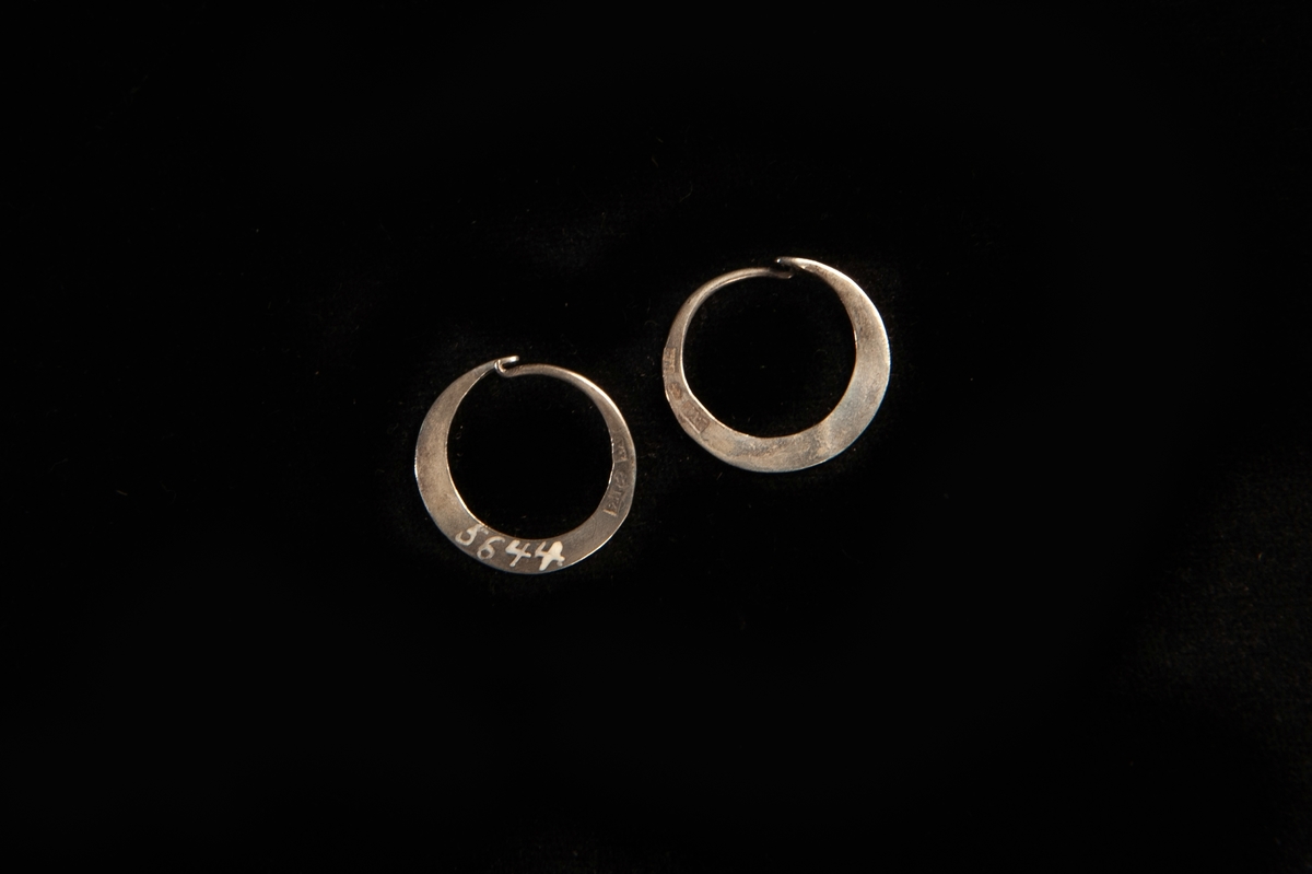 En rund örring av silver. Platt, enkel modell. Hör ihop med JM.5644:1