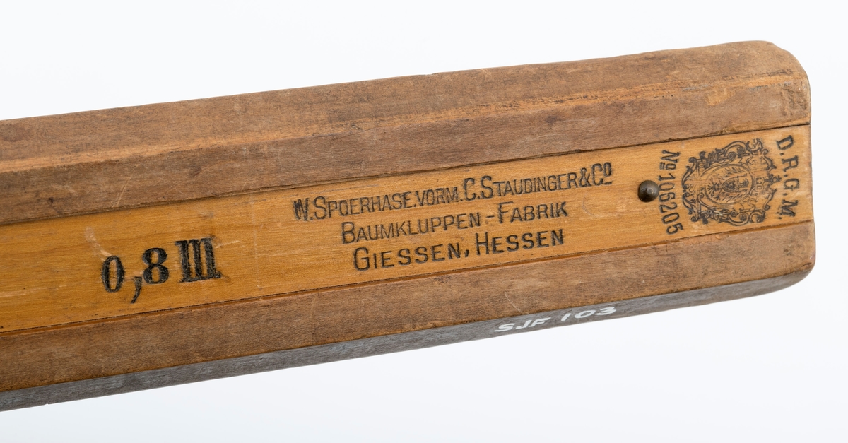 Uvanlig stor måleklave, såkalt «skyveklave», for diameterundersøkelser av stående trær og tømmerstokker. Klaven er lagd av tre. Den har en 101,9 centimeter lang linjal (inkludert den delen som er tappet gjennom den faste klavearmen). Klavelinjalen er 5,0 centimeter bred og snaut 1,4 centimeter tjukk. I den ytre enden er det påtappet en fast klavearm som er 50,6 centimeter lang, hvorav 43,0 centimeter er på den sida av linjalen som skulle vendes mot det objektet som skulle måles. Klaven har også en bevegelig arm, dimensjonert og formet som den faste, men innfestet et 15,7 centimeter langt og 9,5 centimeter bredt (midtmål) handtak, som brukes til å manøvrere den bevegelige armen langs klavelinjalen. Handtaket har en messingskrue, som antakelig skulle kunne regulere friksjonen mellom den bevegelige klavearmen og linjalen. Treverket i linjalen har en påtrykt måleskala med strekmarkeringer med centimetermål på den ene flatsida. Målene avleses der innerkanten av den bevegelige armen møter linjalen når klavearmene ligger an mot barken eller yteveden på trær eller tømmerstokker som skal diametermåles.

Dette er en tyskprodusert tømmerklave, lagd for diametermålinger i et skogbruk der det kunne forekomme trestammer med diametermål som var langt større enn dem som var vanlige i norsk skogbruk. Klavertypen skal særlig ha vært brukt under taksasjonsarbeid.

Eldre gjenstandsbeskrivelse:
«Klaven er lakkert lys brun. Armene er 4 cm brede og 1, 7cm tykke. Mot spissene er de messingbeslått. Den beveglige armen har et kraftig håndtak, 15, 8cm langt og 9, 5cm bredt. Den kan låses med en messingskrue. Denne klaven er en s. k. Heyer-Standinger-klave s om ble brukt mye til taksasjon.»