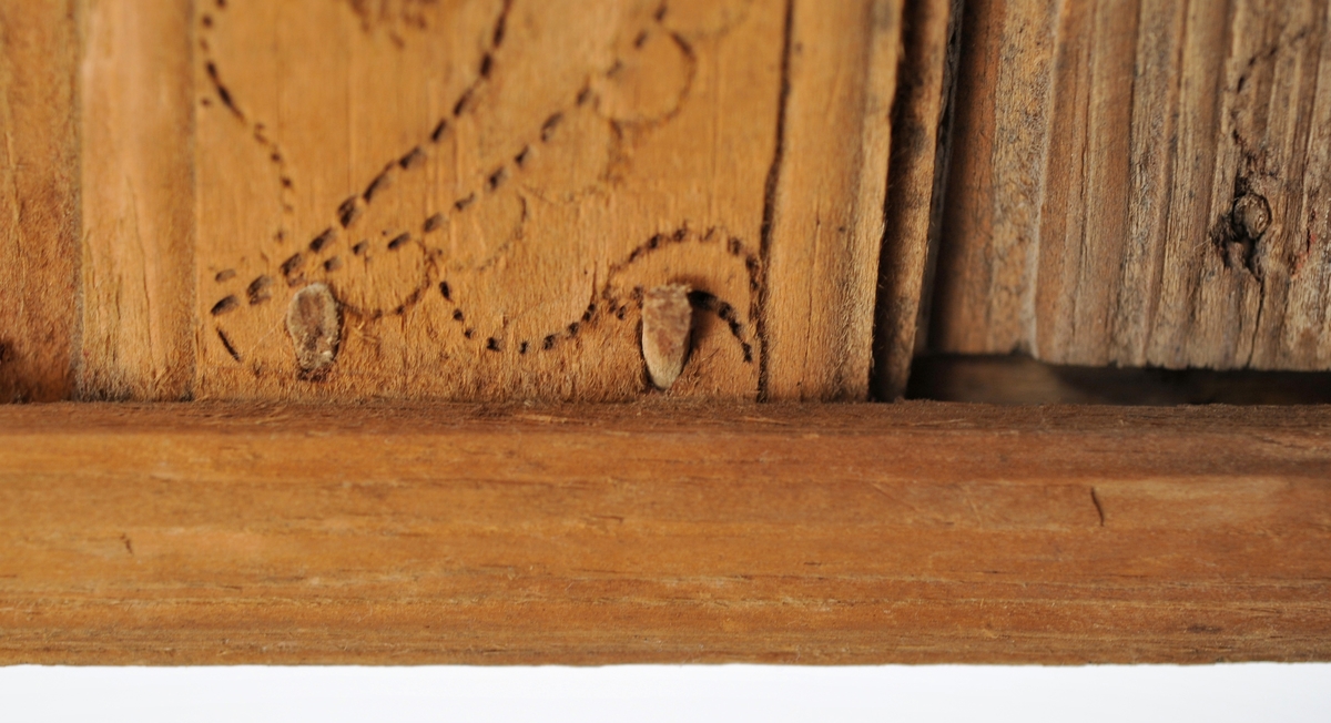 Sveipet laup med rett bakstykke, lagd for å kunne henges på en vegg, der den skulle henge som en beholder, opprinnelig sannsynligvis på et kjøkken. Sett rett ovenfra eller nedenfra er laupen formet som en halvoval. De veggene som skulle vende fram i rommet er lagd av tre forholdsvis tynne (7-8 millimeter) bjørkeskier, som er bøyd i en U-form. Endestykkene er festet i slisser langs kantene av bakstykket ved hjelp av trenagler. Disse tre komponentene er bundet sammen, kant mot kant ved hjelp av bindsler av trefibermateriale. Ytterflatene har svidekor - bølgemønstere på den øverste og nederste, og en akantusranke på den midtre, som er noe bredere enn de to andre. Bakstykket - ryggfjøla - er lagd av et 21,3 centimeter bredt og 1,9 centimeter tjukt (3/4-toms) bord, antakelig av granvirke. Det er vinkelrett avkuttet i den nedre enden, men overenden er avrundet og profilert. Her er det fire gjennbombrutte hull, hvorav tre er runde og det fjerde er firefliket. Det øverste av disse har vært brukt ved oppheng. Også denne delen av laupen har svidekor med elementer av de samme formene som finnes på veggenes forsider. På baksida er det innsvidd en ring, sammensatt av små sirkler, som omgir initialer og årstall: «KSS 1817». Forsida er svijernstemplet «Jh. HØYE». Laupen har et halvovalformet lokk, lagd av granvirke og prydet med et innsvidd mønster, bestående av sirkler, halvsirkler og akantusblader. Også her finner vi det nevnte svijernstempelet. Lokket og bakstykket kan se ut til å ha vært innsatt med et rødbrunt fargestoff. Opprinnelig hengsling mangler. Botnstykket mangler fullstendig, men et innfelt spor nederst på bakstykket og naglehull langs ytterkanten på den nederste buete skia antyder hvordan botnstykket har vært festet.