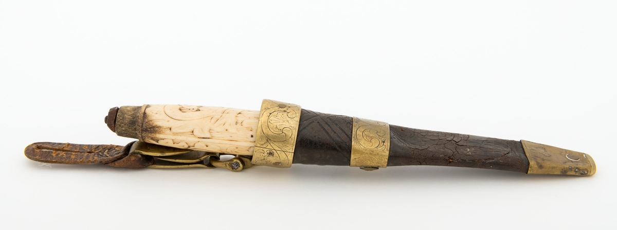 Tollekniv med slire.  Knivens lengde er 20 centimeter.  Den har et gulkvitt beinskaft, som er 10,7 centimeter langt og har et noe konvekst lengdesnitt og et noenlunde ovalt tverrsnitt.  Midten av skaftet måler 2,7 X 2,1 centimeter.  Overflata er prydet med et akantusrelieff.  Langs skaftryggen er det et glatt felt med initialer og årstall: «N P S F[?] 1887».  Det er nærliggende å anta at dette må ha vært en tidligere eiers initialer og anskaffelsesåret.  Beinskaftet har hatt messingholker i begge ender, men bare framholken (nærmest bladet) var intakt da kniven kom til museet.  Den er 1,1 centimeter bred og prydet med linjer langs ytterkantene, ellers glatt.  I overenden av skaftet later det til at ytterspissen på bladtangen er gjenget og påskudd ei kvadratisk mutter med skrådde sideflater.  Bladet er 8,6 centimeter langt og 2,3 centimeter bredt ved brystningen.  Videre framover er imidlertid bladet betraktelig smalere, på grunn av gjentatt sliping.  Den bakre delen av knives nakkeparti er 0,5 centimeter tjukk.

Slira er utført i lær med holker av messing og vedhengslet stropp for knappefeste i bukselinninga.  Samlet lengde er 27,8 centimeter.  Sjølve slira er 16 centimeter lang, fra enden av doppskoen til overkanten av munningsholken (målt på framsida, ikke hengslingspunktet bak).  Slirelæret er mørkebrunt og sammensydd med en søm som er plassert på «baksida», altså den sida som skulle vende inn mot bærerens kropp.  Framsida av doppskoen er merket med årstallet «1851», altså en datering som overgår den vi finner på knivskaftet med 36 år.  På baksida av doppskoen er det inngravert et symmetrisk akantusmønster med C-ornamenter.  Doppskoen er naglet fast i slirelæret ved hjelp av ei gjennombrutt nagle.  Akantusmønsteret fra doppskoens bakside finne vi igjen også på midtholken, som er drøyt 1,8 centimeter bred.  Ettersom holkene ikke er forbundet ved hjelp av sideskinner er også midtholken forankret i læret ved hjelp av nagler på sliras bakside.  Overholken eller munningsholken er 1,9 centimeter bred, og har samme akantusmønster som midtholken og baksida av doppskoen.  Også her er det naglefester i slirelæret.  Munningsholken har en sprekkskade, egentlig et brudd, på det som framstår som baksida av slira.  Her finner vi også et hengslingspunkt med ei U-formet bøyle som danner overgang til ei 4,5 centimeter lang og 1,5 centimeter bred messingspenne.  På forsida av denne spenna er det akantusdekor, på baksida finner vi initialene «B C L».  Spenna må ha vært beregnet på feste av knivslira i linninga på bærerens bukse.  Da kniven ble overlatt til museet var den imidlertid utstyrt med ei lærhempe med en splitt som kunne tjene som festepunkt på en knapp.