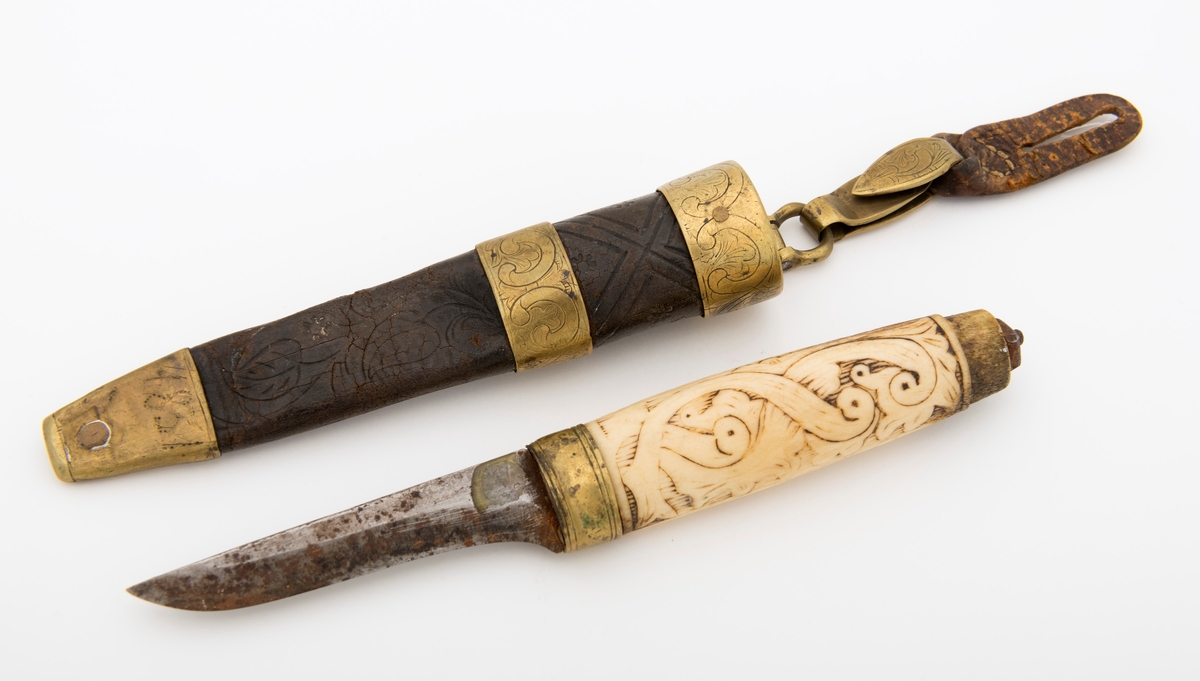 Tollekniv med slire.  Knivens lengde er 20 centimeter.  Den har et gulkvitt beinskaft, som er 10,7 centimeter langt og har et noe konvekst lengdesnitt og et noenlunde ovalt tverrsnitt.  Midten av skaftet måler 2,7 X 2,1 centimeter.  Overflata er prydet med et akantusrelieff.  Langs skaftryggen er det et glatt felt med initialer og årstall: «N P S F[?] 1887».  Det er nærliggende å anta at dette må ha vært en tidligere eiers initialer og anskaffelsesåret.  Beinskaftet har hatt messingholker i begge ender, men bare framholken (nærmest bladet) var intakt da kniven kom til museet.  Den er 1,1 centimeter bred og prydet med linjer langs ytterkantene, ellers glatt.  I overenden av skaftet later det til at ytterspissen på bladtangen er gjenget og påskudd ei kvadratisk mutter med skrådde sideflater.  Bladet er 8,6 centimeter langt og 2,3 centimeter bredt ved brystningen.  Videre framover er imidlertid bladet betraktelig smalere, på grunn av gjentatt sliping.  Den bakre delen av knives nakkeparti er 0,5 centimeter tjukk.

Slira er utført i lær med holker av messing og vedhengslet stropp for knappefeste i bukselinninga.  Samlet lengde er 27,8 centimeter.  Sjølve slira er 16 centimeter lang, fra enden av doppskoen til overkanten av munningsholken (målt på framsida, ikke hengslingspunktet bak).  Slirelæret er mørkebrunt og sammensydd med en søm som er plassert på «baksida», altså den sida som skulle vende inn mot bærerens kropp.  Framsida av doppskoen er merket med årstallet «1851», altså en datering som overgår den vi finner på knivskaftet med 36 år.  På baksida av doppskoen er det inngravert et symmetrisk akantusmønster med C-ornamenter.  Doppskoen er naglet fast i slirelæret ved hjelp av ei gjennombrutt nagle.  Akantusmønsteret fra doppskoens bakside finne vi igjen også på midtholken, som er drøyt 1,8 centimeter bred.  Ettersom holkene ikke er forbundet ved hjelp av sideskinner er også midtholken forankret i læret ved hjelp av nagler på sliras bakside.  Overholken eller munningsholken er 1,9 centimeter bred, og har samme akantusmønster som midtholken og baksida av doppskoen.  Også her er det naglefester i slirelæret.  Munningsholken har en sprekkskade, egentlig et brudd, på det som framstår som baksida av slira.  Her finner vi også et hengslingspunkt med ei U-formet bøyle som danner overgang til ei 4,5 centimeter lang og 1,5 centimeter bred messingspenne.  På forsida av denne spenna er det akantusdekor, på baksida finner vi initialene «B C L».  Spenna må ha vært beregnet på feste av knivslira i linninga på bærerens bukse.  Da kniven ble overlatt til museet var den imidlertid utstyrt med ei lærhempe med en splitt som kunne tjene som festepunkt på en knapp.