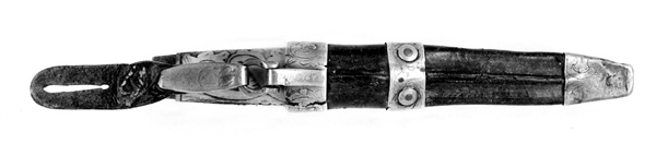 Tollekniv med slire.  Knivens lengde er 20 centimeter.  Den har et gulkvitt beinskaft, som er 10,7 centimeter langt og har et noe konvekst lengdesnitt og et noenlunde ovalt tverrsnitt.  Midten av skaftet måler 2,7 X 2,1 centimeter.  Overflata er prydet med et akantusrelieff.  Langs skaftryggen er det et glatt felt med initialer og årstall: «N P S F[?] 1887».  Det er nærliggende å anta at dette må ha vært en tidligere eiers initialer og anskaffelsesåret.  Beinskaftet har hatt messingholker i begge ender, men bare framholken (nærmest bladet) var intakt da kniven kom til museet.  Den er 1,1 centimeter bred og prydet med linjer langs ytterkantene, ellers glatt.  I overenden av skaftet later det til at ytterspissen på bladtangen er gjenget og påskudd ei kvadratisk mutter med skrådde sideflater.  Bladet er 8,6 centimeter langt og 2,3 centimeter bredt ved brystningen.  Videre framover er imidlertid bladet betraktelig smalere, på grunn av gjentatt sliping.  Den bakre delen av knives nakkeparti er 0,5 centimeter tjukk.

Slira er utført i lær med holker av messing og vedhengslet stropp for knappefeste i bukselinninga.  Samlet lengde er 27,8 centimeter.  Sjølve slira er 16 centimeter lang, fra enden av doppskoen til overkanten av munningsholken (målt på framsida, ikke hengslingspunktet bak).  Slirelæret er mørkebrunt og sammensydd med en søm som er plassert på «baksida», altså den sida som skulle vende inn mot bærerens kropp.  Framsida av doppskoen er merket med årstallet «1851», altså en datering som overgår den vi finner på knivskaftet med 36 år.  På baksida av doppskoen er det inngravert et symmetrisk akantusmønster med C-ornamenter.  Doppskoen er naglet fast i slirelæret ved hjelp av ei gjennombrutt nagle.  Akantusmønsteret fra doppskoens bakside finne vi igjen også på midtholken, som er drøyt 1,8 centimeter bred.  Ettersom holkene ikke er forbundet ved hjelp av sideskinner er også midtholken forankret i læret ved hjelp av nagler på sliras bakside.  Overholken eller munningsholken er 1,9 centimeter bred, og har samme akantusmønster som midtholken og baksida av doppskoen.  Også her er det naglefester i slirelæret.  Munningsholken har en sprekkskade, egentlig et brudd, på det som framstår som baksida av slira.  Her finner vi også et hengslingspunkt med ei U-formet bøyle som danner overgang til ei 4,5 centimeter lang og 1,5 centimeter bred messingspenne.  På forsida av denne spenna er det akantusdekor, på baksida finner vi initialene «B C L».  Spenna må ha vært beregnet på feste av knivslira i linninga på bærerens bukse.  Da kniven ble overlatt til museet var den imidlertid utstyrt med ei lærhempe med en splitt som kunne tjene som festepunkt på en knapp.