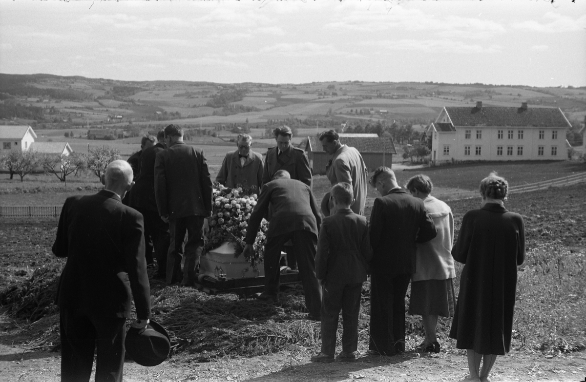 Begravelse ved Hoff kirke juni 1955. Serie på 9 bilder, der de første viser prosesjonen fra gravkapellet il grava, de øvrige ved grava. Ifølge informmant er dette begravelsen etter Ludvig Madshus som var kjøpmann i Lillo. Foraan prosesjonen går presten, som trolig er Finn Sommer, og kirketjener Pål Rødset. Nærmest bak kista trolig Ludvigs hustru Helga født Hagen, og deres to sønner Johan Ludvig (i midten) og Olav. De øvrige er ukjente.