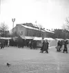 Hindersmässan i Örebro den 28 januari 1937. Marknadsstånd på Stortorgets östra del med människor spatserande framför.