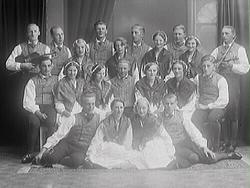 Tvååkers danslag. I bakre raden står två män med fioler.
1: 