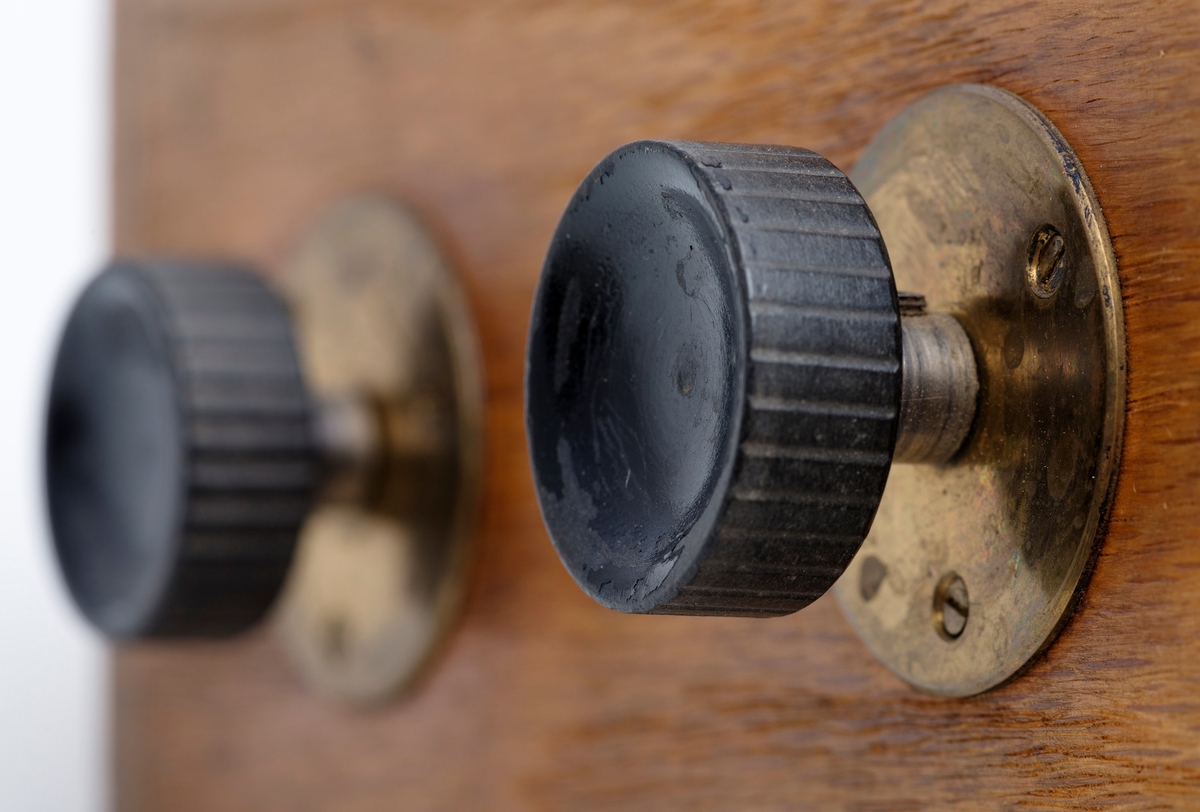 Kubikkberegningsapparat, levert av produsenten F. A. Krog i Skovveien i Kristiania, antakelig tidlig på 1900-tallet.  Apparatet er formet som et rektangulært skrin, utført i eiketre, men med "lokk" av ei messingplate.  Langs midtaksen på dette lokket er det ei lang, smal, rektanuglær spalte med glass under.  Gjennom denne ser vi ned på en tabell.  Tabellen er trykket på en papirrull, som er forankret på to valser nede i skrinet.  Tabellen kan beveges ved hjelp av dreiehjul på skrinets endeflater, to på hver side, ett i hver ende av de nevnte valsene.  Lengst til høyre i tabellvinduet finner vi "klassifiseringsinformasjon" - angivelser av stokklengder, diametere og salgsklasser.  Langs den øvrige delen av vinduet kan man lese av kubikkmeterangivelser for fra 1 til 70 stokker med samme dimensjoner og klassespesifikasjon.  Avlesinga skjer fra en tolinjet tabell på den nevnte papirrullen inne i skrinet, og med stokketallesangivelser på lokket - 1-35 stokker på oversida av vinduet og 36-70 stokker på undersida.  Det nevnte emaljerte lokket, som er hvitt med svarte tall og bokstaver, er skrudd fast til toppen av skrinet.  Det er grunn til å tro at valsene med tabellen må være montert før dette ble påsatt.  Skrinet er ellers lagd av høvlet eiketre, og den holdes sammen av de nevnte skruene i lokket og spiker fra botnstykket.  På standflata er det også hengslet en klaff, som kan vippes opp, slik at lokket skrår mot brukeren når apparatet brukes på et bord eller et annet plant underlag. 