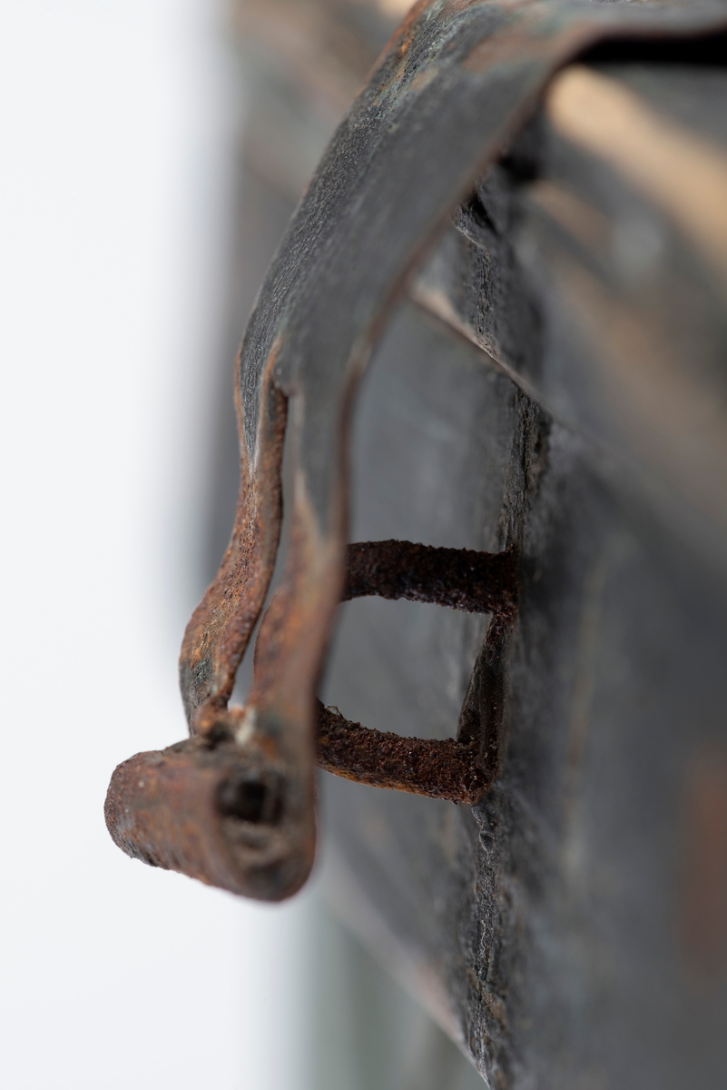 Sponkurven har en rektangulær form, og den har et lokk som er delt i to, hvorav den ene delen kan åpnes. Lokket er hengslet sammen med fire lærbiter.  Lokket festes med en metallhempe. 

Kurven er i skråflettet spon, og det er sprikret på en kant/avslutning på kurven. Kurven har også en hank som er tilspikket. Den har en umalt innside, yttersiden er malt grønn, og kanten og hanken er malt svart. 