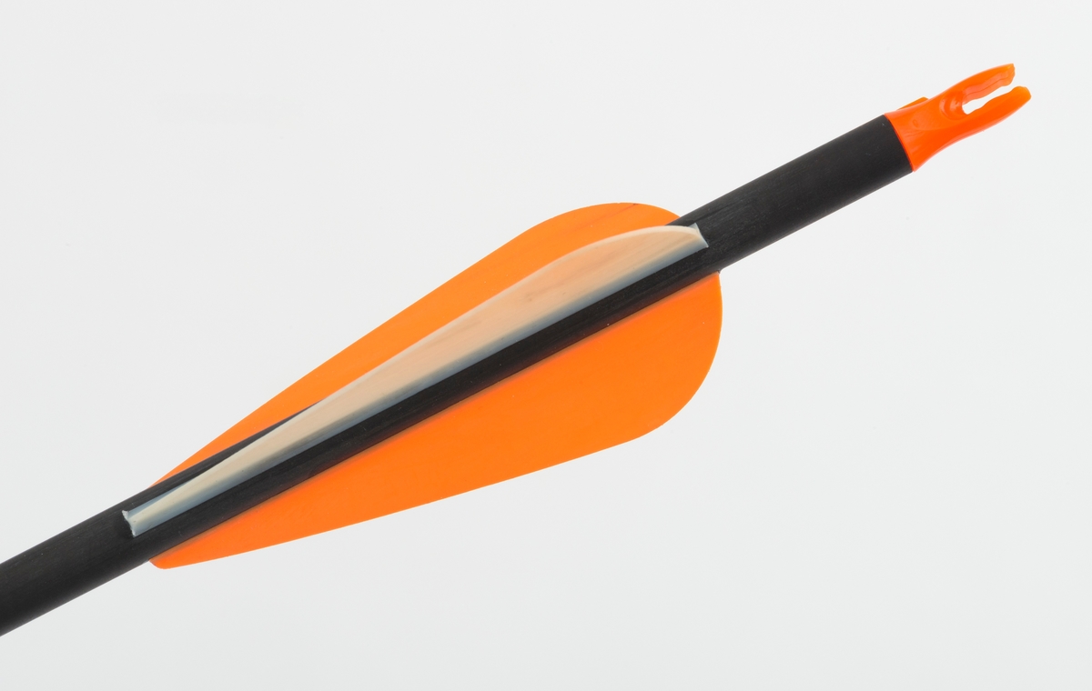 Pil av karbonmateriale (karbonfiber) utstyrt med jaktpil (spiss) med tre skjær. Skjærene er av stål. Pilen har styrefjær av kunststoff i oransje og hvitt. Pilen har en oransje nock av plastmateriale i enden som tres på buestrengen. 
Pilen og har gjenger i ene enden, slik at spissen kan byttes etter behov. 