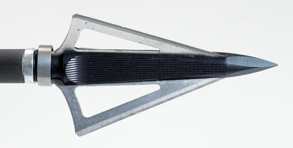 Pil av karbonmateriale (karbonfiber) utstyrt med jaktpil (spiss) med tre skjær. Skjærene er av stål. Pilen har styrefjær av kunststoff i oransje og hvitt. Pilen har en oransje nock av plastmateriale i enden som tres på buestrengen. 
Pilen og har gjenger i ene enden, slik at spissen kan byttes etter behov. 