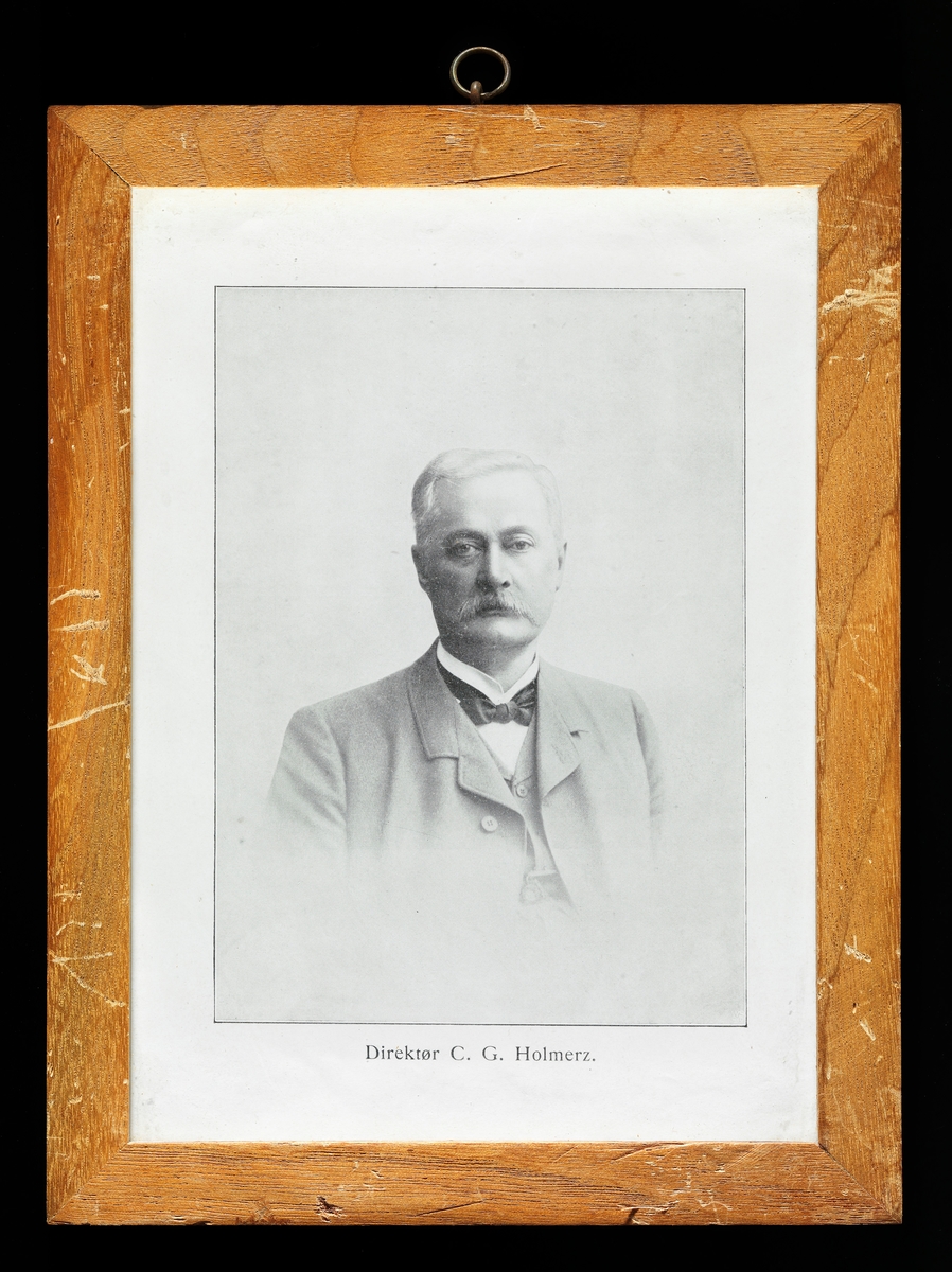 Trykt gjengivelse av fotografisk portrett av den en svenske forstmannen Conrad Georg Gottfrid Holmerz (1839-1907).  Portrettet er et studioopptak, der den portretterte mannen sitter med ansiktet vendt mot fotografen.  Han var kledd i dress med vest ogu kvit skjorte underl.  I halsen var han pyntet med ei svart sløyfe.  Han hadde bart og sidestrøket hår.  C. G. G. Holmerz ble født i Konungssund i Östergötland.  Faren var fanejunker, altså offiser med forholdsvis lav rang.  Familien flyttet til Norrköping, der C. G. G. Holmerz gikk på skole.  Han var en dyktig elev og viste stor interesse for naturfag, særlig for ornitologi.  Det var imidlertid ingen selvfølge at han skulle bli akademiker.  Med gode vitnemål fra skolen fikk han derimot ansettelse som kontorist i en tobakksfabrikk.  Gjennom kameraten Axel Cnattingius ble han imidlertid også kjent med skogforvalter C. W. Lundborg, som var en interessert jeger og ornitolog.  Han skaffet de to unge entusiastene arbeid ved Norrköpings lyceum.  I denne perioden (1861) tok Holmerz eksamen artium.  Deretter arbeidet både Cnattingius og Holmerz, både med skogfaglige oppgaver, utstopping av fugler og innsamling av egg til ei stor ornitologisk samling.  I 1862 begynte de to kameratene på skogskole, og året etter tok de eksamen.  Deretter ble Holmerz assistent for «öfverjägmestaren» i Östergötlands län.  Her arbeidet han i tre år med oppmålinger og kartleggingsarbeid.  Deretter var han allmenningsbestyrer et par år, før Holmerz og Cnattingius ble utnevnt til skogforvaltere i to nabodistrikter i Norrland.  Sjøl om embetet innebar mye «forstlig polistjänst» likte Holmerz seg i Nord-Sverige, hvor han kunne kombinere skogfaglige oppgaver med jakt og naturopplevelser.  I 1870 besøkte han imidlertid en utstilling i København, og da han på tilbaketuren var innom Stockholm ble han meget overraskende tilbudt et vikariat i stillingen etter den nettopp avdøde direktøren for det svenske skogsinstituttet.  Han tok utfordringen, og måtte dermed gi seg i kast med oppgaver han ikke var forberedt på.  Han underviste på dagtid og brukte kveldene og nettene på å sette seg inn i fagstoffet.  Holmerz var ikke den eneste som var overrasket over at han ble tilbudt lederstillingen for skogsinstituttet, og det var krefter som arbeidet for å omstøte denne ansettelsen.  Holmerz ville imidlertid fortsette, noe han også fikk anledning til.  I begynnelsen var han ansvarlig for all undervisning og for skolens administrasjon og økonomistyring.  Studentene hadde enten ettårig skogskole eller praksis under veiledning av en kompetent forstmann.  Deretter fulgte to år på skogsinstituttet, med blandet teoretisk og praktisk undervisning.  Holmerz omorganiserte studietilbudet, slik at de to årskullene fikk separate opplegg.  Han skrev også lærebøker – «Studier i skogstaxation», «Handledning för skogskötseln i Norrland», «Studier i skogstaxation» og «Vägledning i skogshushållning».  Bøkene er sterkt påvirket av tyske forbilder.  Han hadde imidlertid lært av egne erfaringer, og modifiserte den sterke preferansen for snauhogster – «kalhyggesbruk» – som hadde vært så dominerende blant svenske «jägmästare» (i motsetning til de norske).  Han var også opptatt av at faglitteraturen måtte forstås i lys av det praktiske skogbruket den var sprunget ut av.  Derfor foretok han – dels på egen regning – studieturer både til Tyskland, Østerrike, Sveits, Frankrike og Norge.  Ved siden av sine undervisningsoppgaver ved skogsinstituttet bidro Holmerz også til det svenske skogfaglige miljøets utvikling i arbeidet med «Tidsskrift för skogshushållning», der han var redaktør fra 1895. 