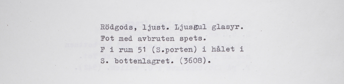 Koniskt ben i yngre rödgods. Sannolikt från en trebensgryta. Benet avbrutet. Rester av gul glasyr på kärlbukens in- och utsida. Tillverkad i södra Skandinavien.