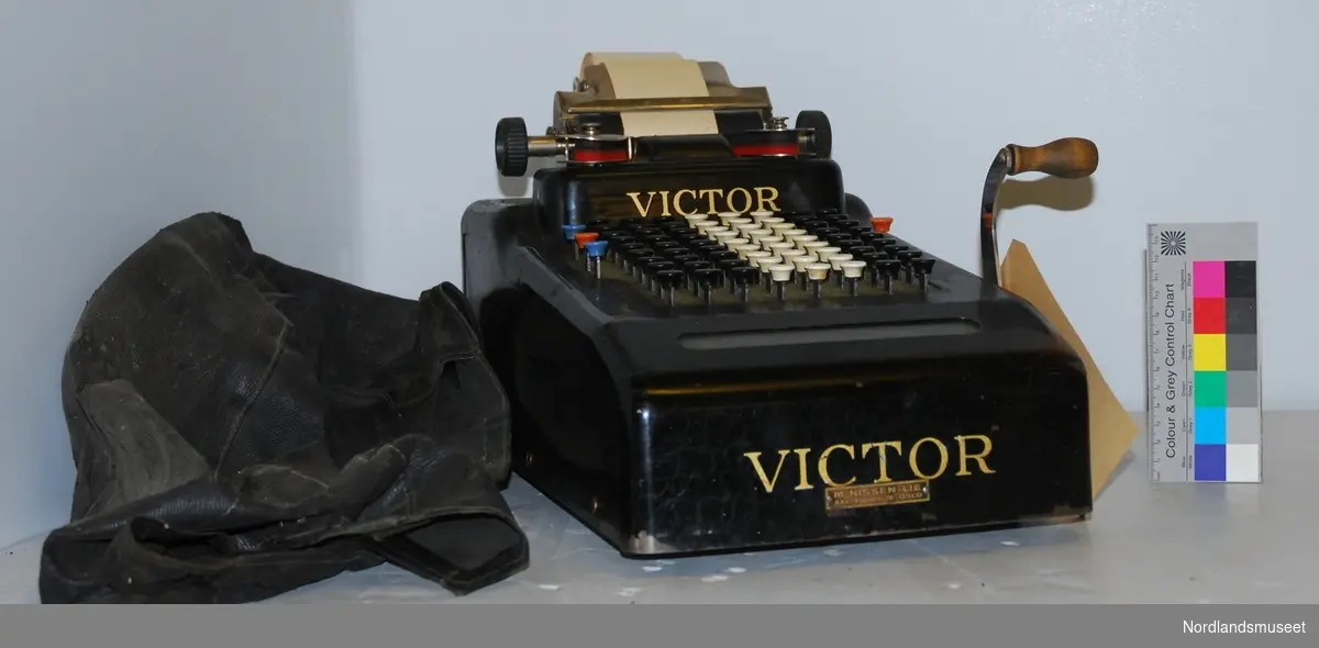 black lacquered calculating machine, with ink ribbon and paper roll, black textile cover