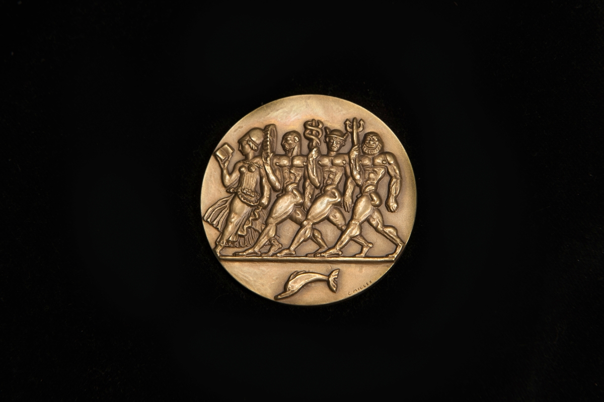Utställningsmedalj av metall, förvarad i rund pappask klädd i blå papp med guldigt tryck på locket, "C.C. Sporrong  Co, kungsgatan 17, Stockholm". Även botten är tryckt med samma text i svart på beige botten.

Medaljens åtsida präglad med 4 persongestalter och en delfin, och frånsidan präglad med ett krönt lejon hållandes en sköld med tre kronor, samt texten "Jubileumsutställningen Göteborg" och årtalet 1923. Medaljkonstnär C. Milles.
