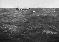 Havarert dampskip, bølger slår over fartøyet.