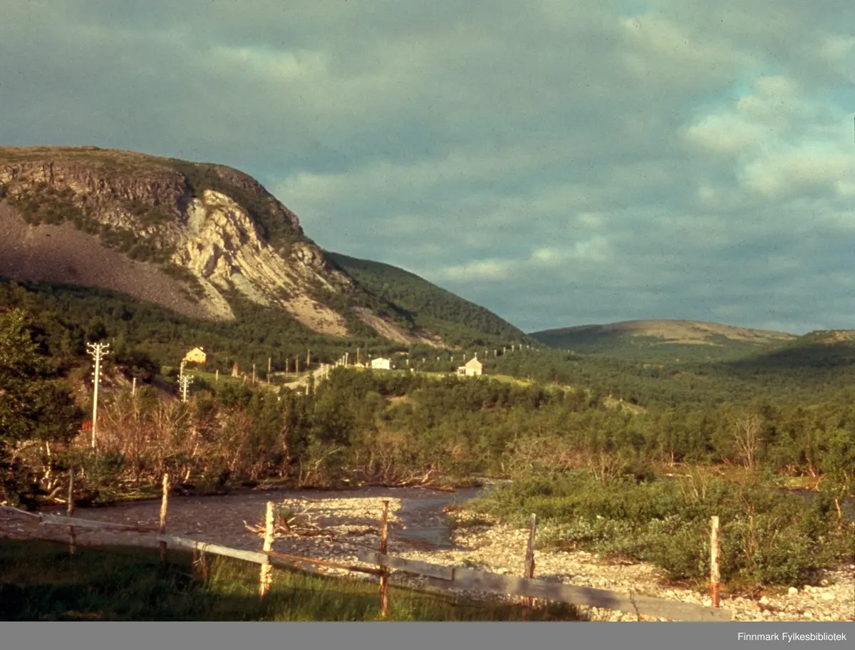 Kunes, sommeren 1964. I forgrunnen: Sørelva.I bakgrunnen: Lille-Lowdes. Kunes (samisk: Gussanjárga) er en bygd i Lebesby kommune i Finnmark. Stedet ligger innerst i Storfjorden.
Fylkesvei 98 passerer igjennom Kunes. Fotografen, Richard Bergh, har også skrevet et hefte som heter: "Når vi sitt' her og prate". Folk i Laksefjord forteller. Norsk Folkeminnelags skrifter nr. 122. H. Aschehoug & Co. (W. Nygaard). Oslo 1980. ISBN 82-03-10187-9