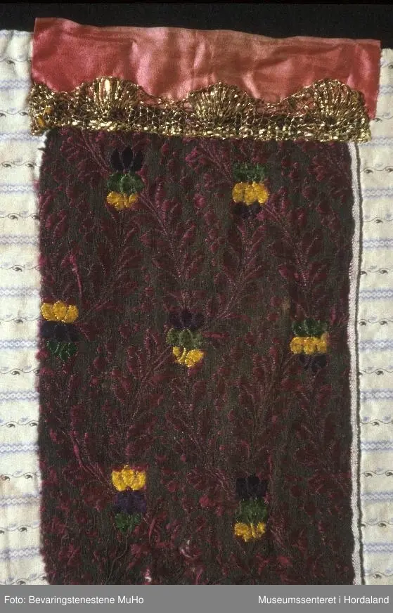 blomstermønster, gullband og rosasilkeband øvst.