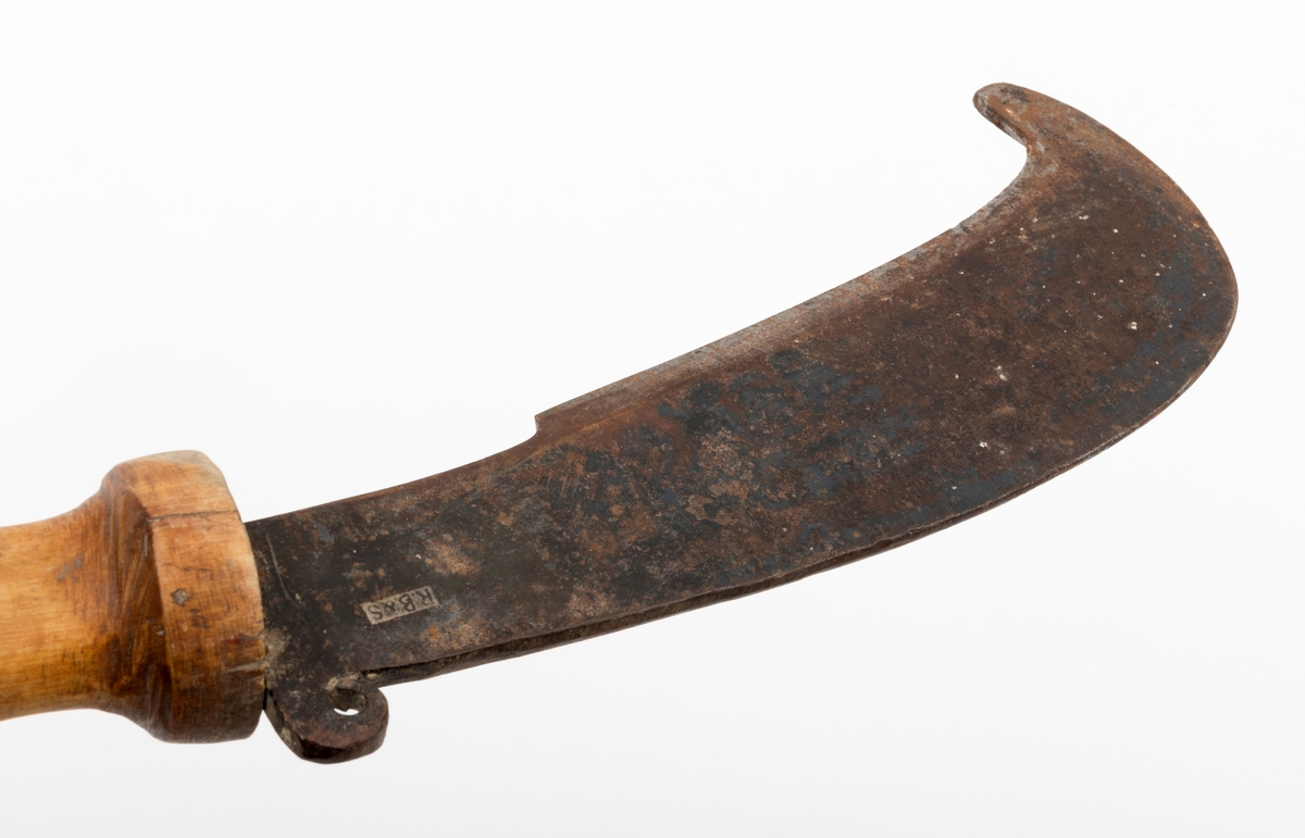 Kniv, lauvkniv, bestående av et håndtak og kraftig blad med egg. Bladet har en innoverbøyd hake ved spissen på eggsida. Bladet er merket med produsentens stempel. Det er innslag av noe rust på bladet. Tangen på knivbladet går tvers gjennom skaftet. Skaftet er solid utformet med en fortykning mot bladet som beskytter brukerens hånd. Lauvkniver av denne typen ble brukt til fôrsanking.